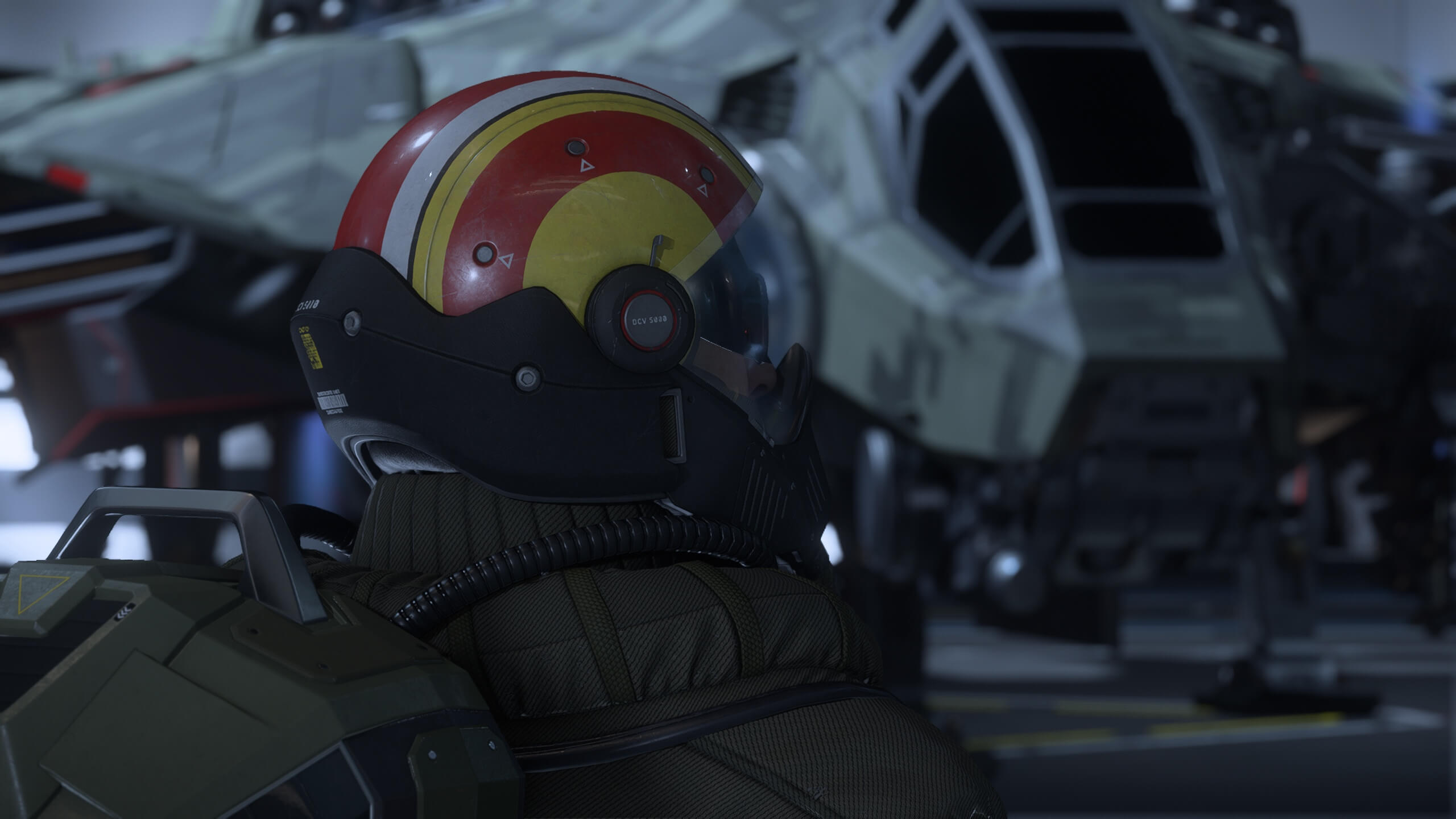 Pilote DAWNFALL en combinaison de vol devant un vaisseau de combat dans un hangar